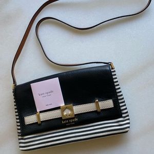 Kate Spade black and white striped crossbody bag with brown strap.